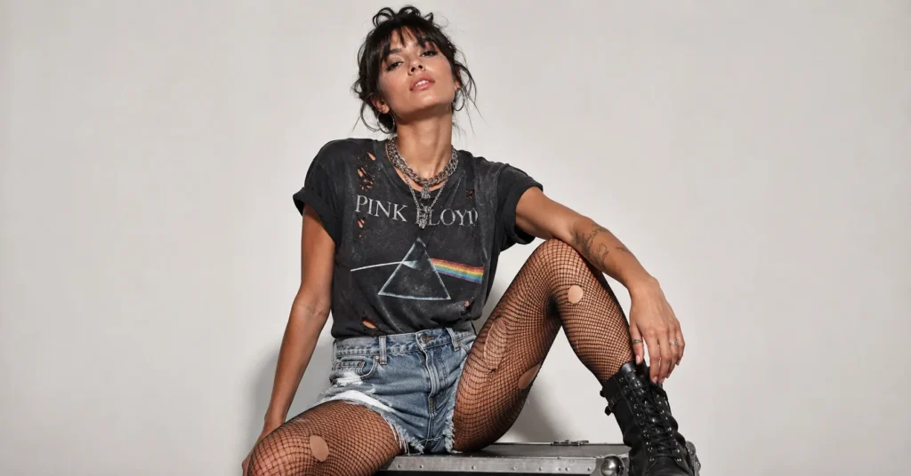 Kesha concert outfit ideas featuring distressed denim shorts, fishnet tights, and combat boots.