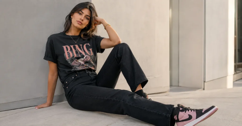 Black and pink outfit ideas featuring casual street style with graphic tee and black denim.