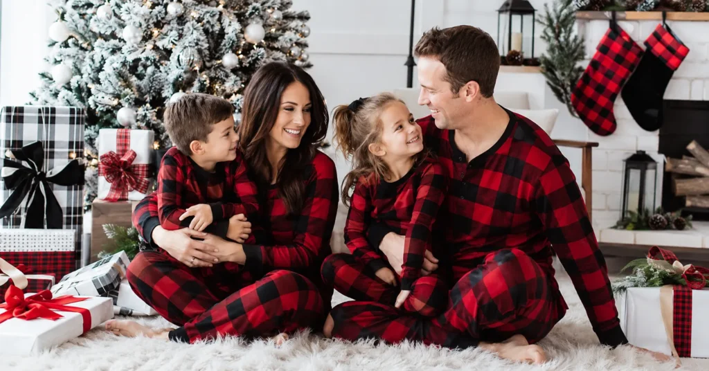 Family christmas outfit ideas with matching plaid pajamas in a cozy festive holiday setting.