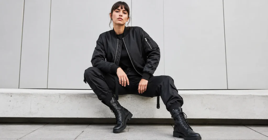 Woman in matte black bomber jacket styled as futuristic cyberpunk outfits for urban fashion.