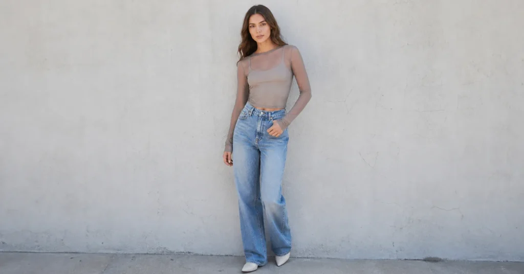 Sheer clothing trends with mesh top layered over inner shirt and jeans