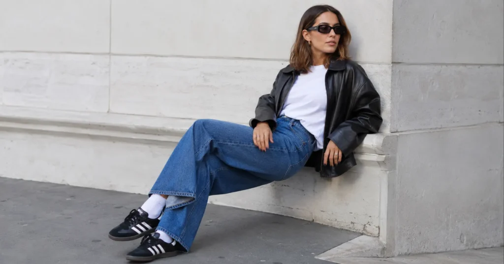 Stylish samba adidas outfit featuring a woman in wide-leg jeans and Adidas Samba sneakers styled with a modern streetwear look.