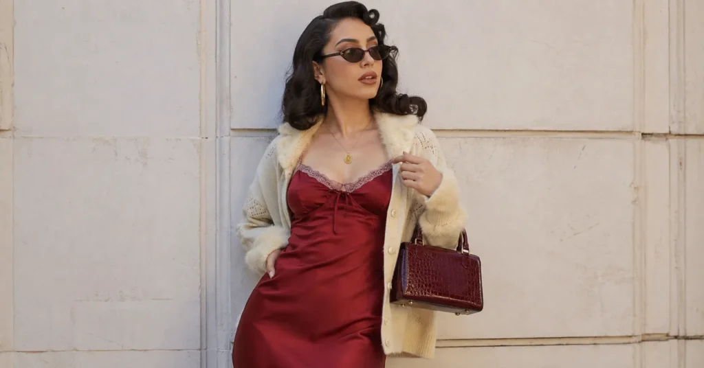 Kali Uchis outfit ideas featuring a satin slip dress, gold hoops, cat-eye sunglasses, and retro glam styling.