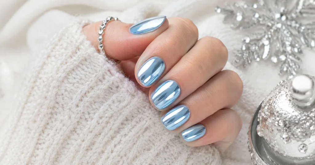 12 Dazzling Winter Nail Art Ideas for a Trendy Seasonal Manicure 6 Winter Nail Art Ideas featuring sleek icy blue chrome nails with a frosty metallic finish.