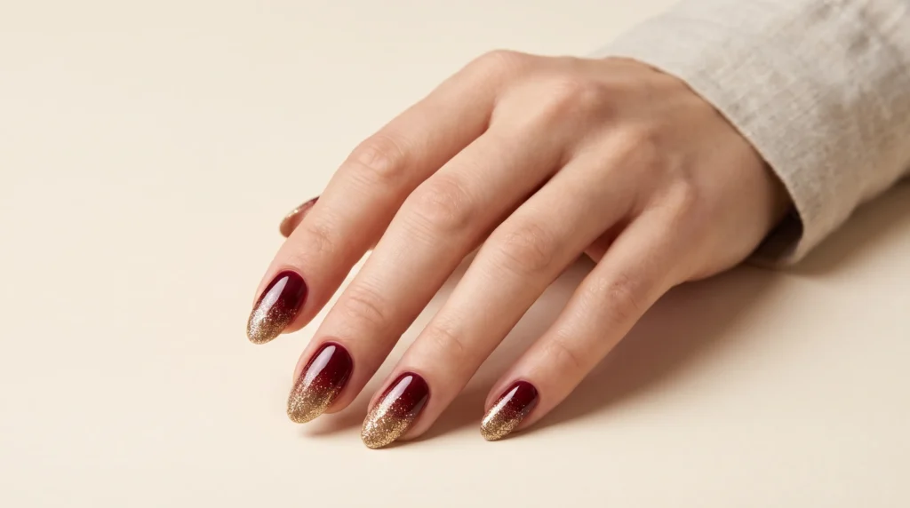Burgundy and Gold Nails: 10 Luxurious Ideas, Shades & Pro Tips for a Rich Manicure 9 Festive burgundy and gold nails with a gradual gold glitter ombré gradient from base to tip.
