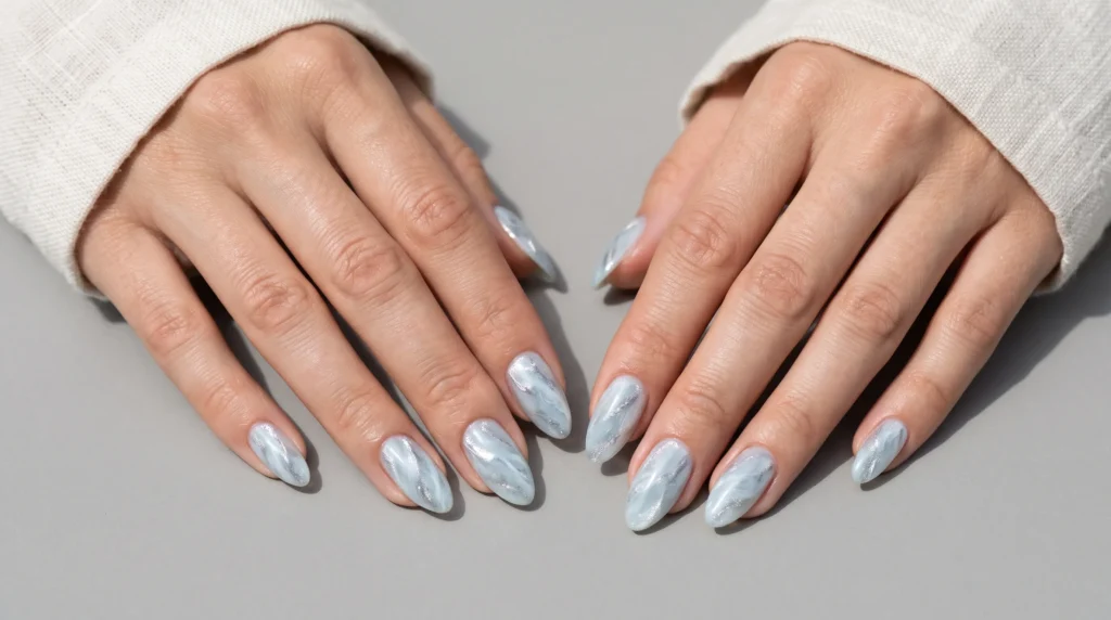 Icy Blue Nails: 10 Stunning Ideas, Shades & Pro Tips for a Frosty Manicure 12 Ice quartz marble manicure with white and silver veins on pale icy blue nails.