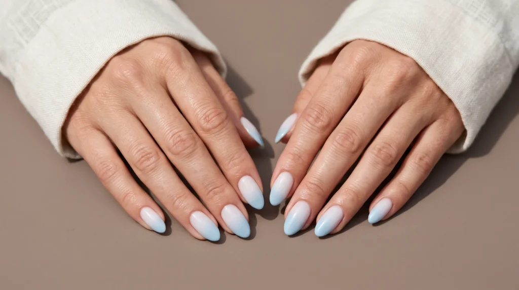 Icy Blue Nails: 10 Stunning Ideas, Shades & Pro Tips for a Frosty Manicure 8 Smooth white-to-blue ombré gradient on medium almond icy blue nails.